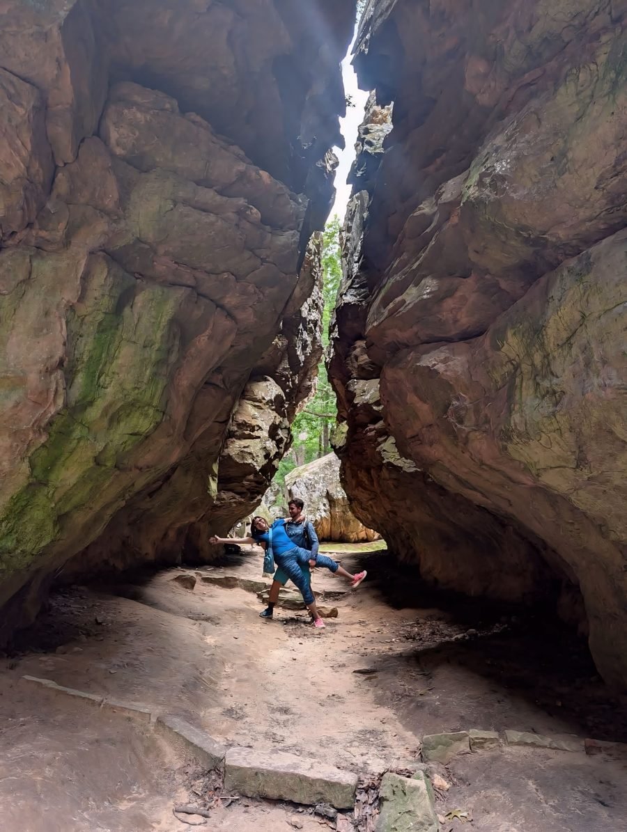 A dip in the middle of a slot canyon, sandstone walls rising on both sides.